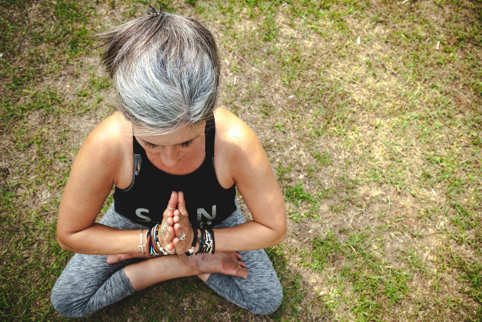 Reife Frau in meditativer Ruhehaltung im Freien