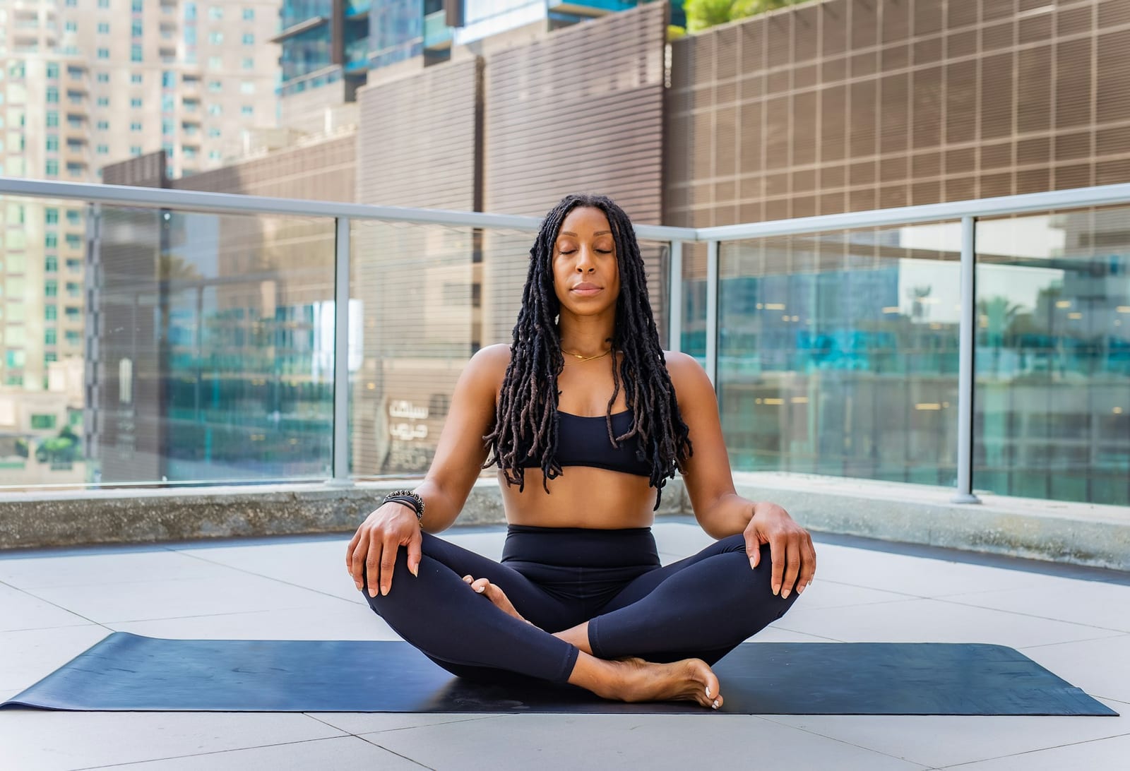 Reife Frau sitzt konzentriert auf einer Yogamatte